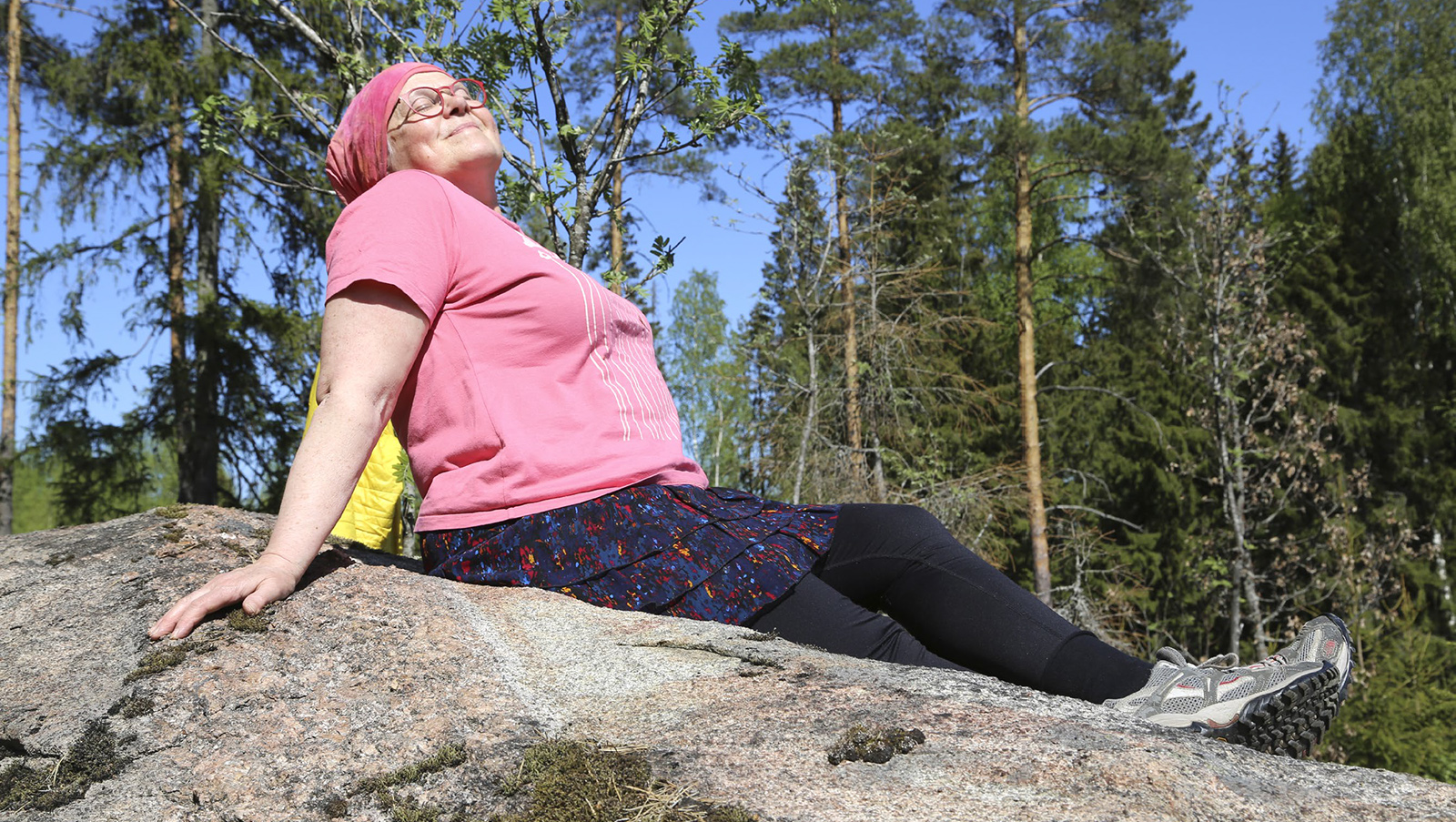 Nainen makaa kalliolla