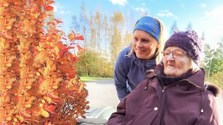 Vanhempi ja nuorempi nainen yhdessä ulkona.