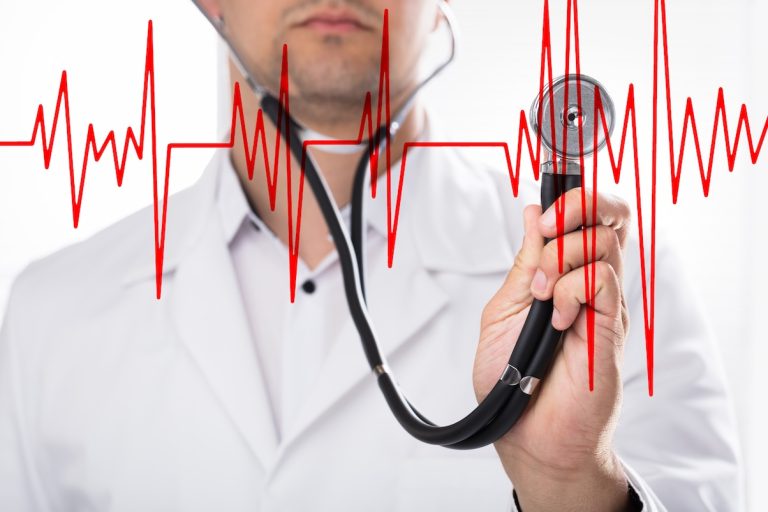 Lääkrin kuvan edessä sydämen ekg-käyrä.