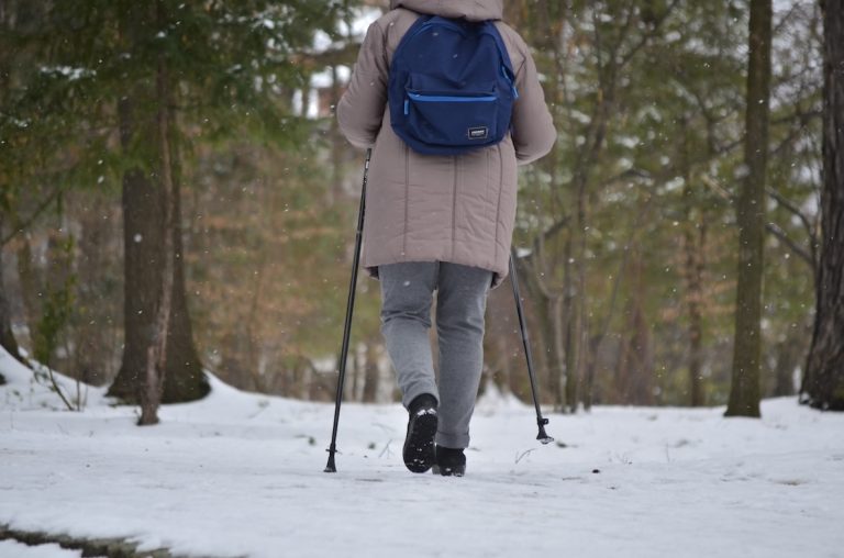 Ihminen kävelyllä talvisessa metsässä