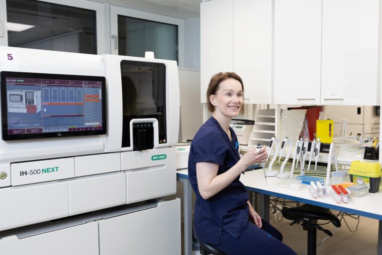 Nuori hymyilevä nainen ty7öskentelee laboratoriossa.