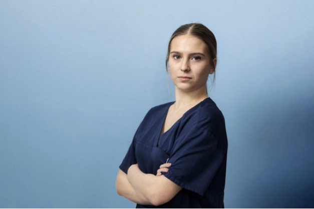 nuori lähihoitaja seisoo kädet puuskassa