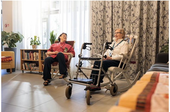 Naiset istuvat ja juttelevat aulatilassa