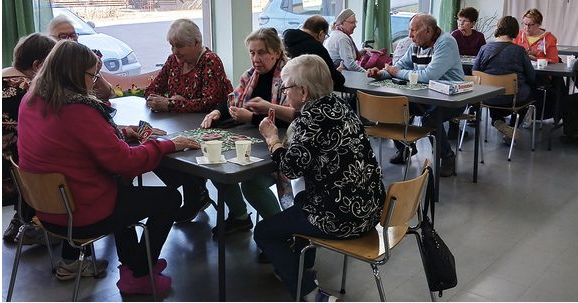 Ikäihmisiä juttelemassa pöydän ääressä